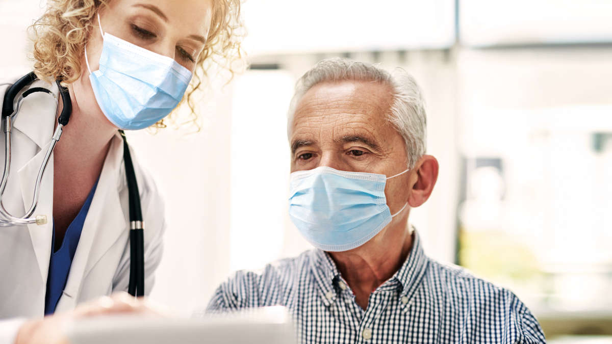 Female doctor talking to older male patient